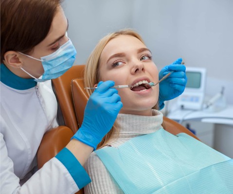 young female patient getting dental treatment in the doctor’s office