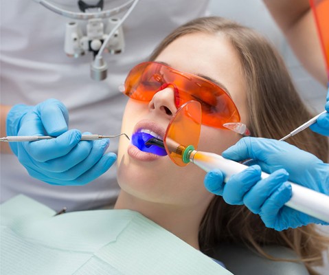 young female patient getting dental treatment in the doctor’s office